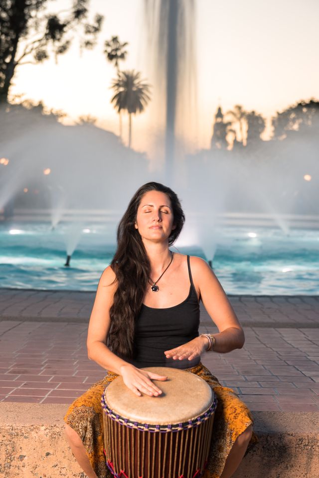 Misty playing djembe by fountain